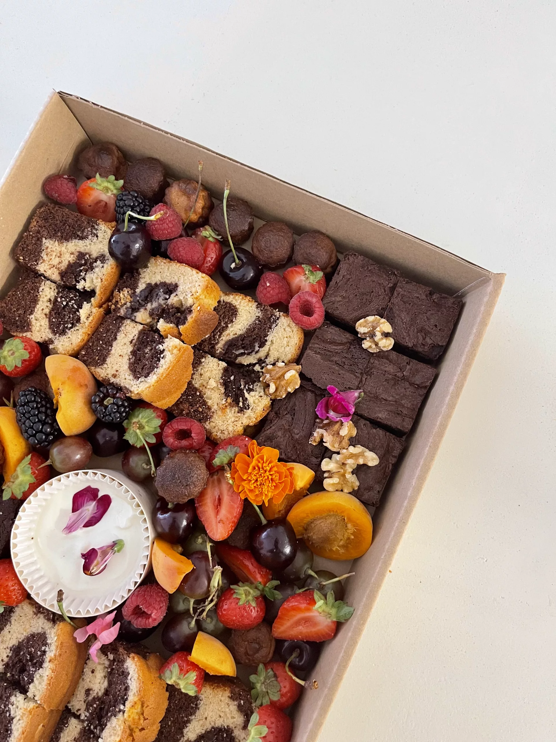 Caja dulce Sauge Marbella con brownies, trufas de chocolate, bizcocho marmolado y fruta fresca